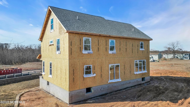 view of property exterior featuring a shingled roof and crawl space