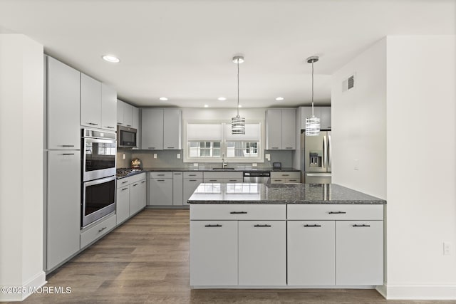 305 W 18th St, Ship Bottom, NJ 08008 - kitchen featuring stainless steel appliances, a sink, wood finished floors, dark stone counters, and decorative light fixtures