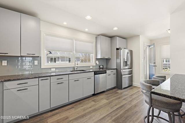 305 W 18th St, Ship Bottom, NJ 08008 - kitchen with appliances with stainless steel finishes, a sink, light wood-style flooring, backsplash, and dark stone countertops