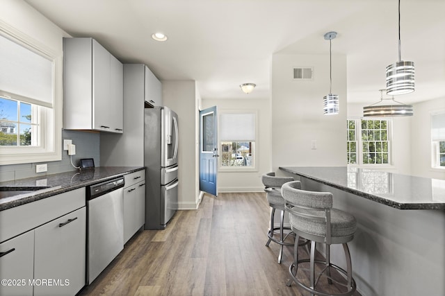 305 W 18th St, Ship Bottom, NJ 08008 - kitchen featuring stainless steel appliances, a breakfast bar, wood finished floors, dark stone counters, and recessed lighting