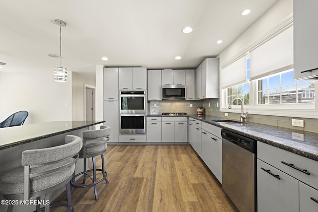 305 W 18th St, Ship Bottom, NJ 08008 - kitchen with appliances with stainless steel finishes, a sink, tasteful backsplash, pendant lighting, and wood finished floors