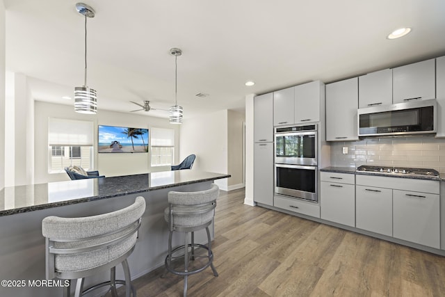 305 W 18th St, Ship Bottom, NJ 08008 - kitchen featuring appliances with stainless steel finishes, a kitchen breakfast bar, a ceiling fan, tasteful backsplash, and decorative light fixtures