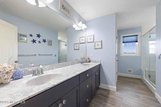 305 W 18th St, Ship Bottom, NJ 08008 - bathroom featuring double vanity, a stall shower, wood finished floors, and baseboards