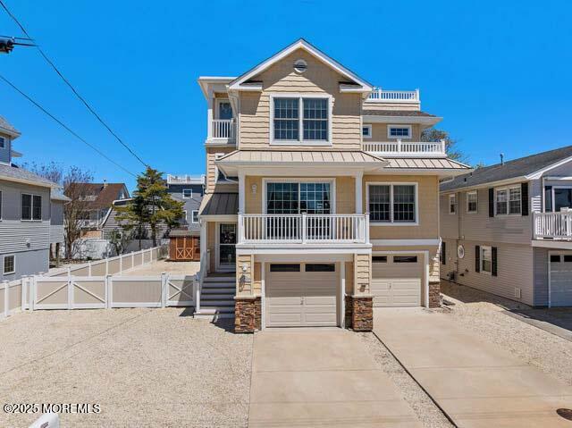 305 W 18th St, Ship Bottom, NJ 08008 - view of front facade with a standing seam roof, driveway, a garage, stone siding, and metal roof