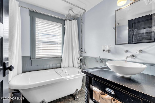 full bathroom featuring vanity, wainscoting, and a freestanding tub
