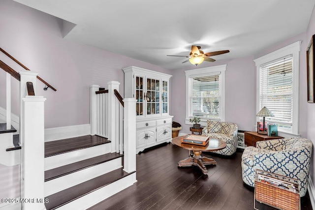 living room with dark wood-style flooring, ceiling fan, and stairway