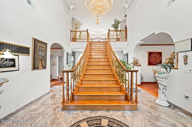 8 Tiberon Dr, Holmdel, NJ 07733 - staircase featuring a high ceiling, arched walkways, baseboards, and visible vents