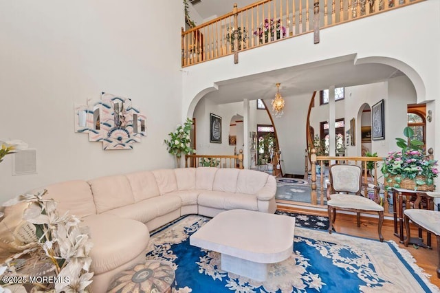 8 Tiberon Dr, Holmdel, NJ 07733 - living room with arched walkways, a chandelier, a towering ceiling, and wood finished floors