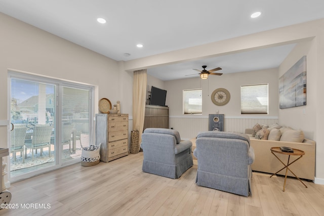 living room with light wood-type flooring, a ceiling fan, and recessed lighting