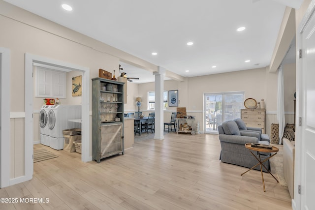 interior space featuring light wood-style floors, recessed lighting, washing machine and dryer, and ornate columns