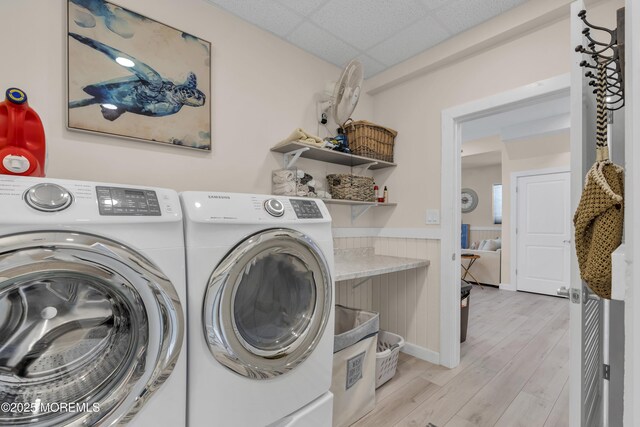 laundry room featuring independent washer and dryer, laundry area, wainscoting, and light wood-style flooring