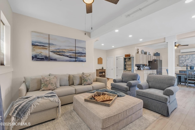 living area with recessed lighting, ceiling fan, a wall unit AC, and light wood-type flooring