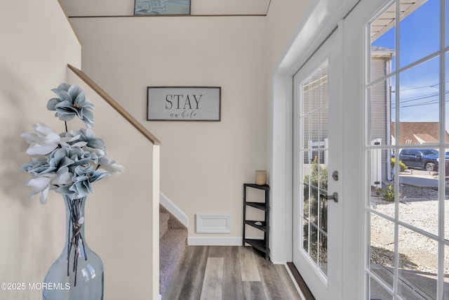 foyer entrance featuring plenty of natural light, baseboards, wood finished floors, and stairway