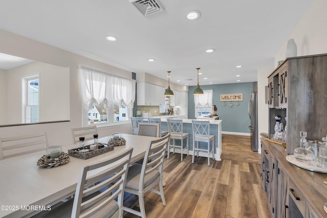 dining area with recessed lighting, visible vents, a healthy amount of sunlight, and wood finished floors