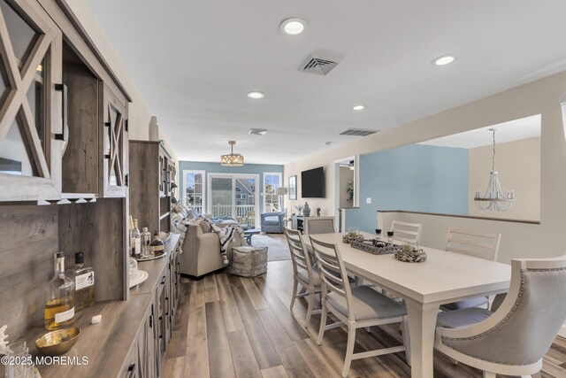 dining area featuring visible vents, recessed lighting, wood finished floors, and an inviting chandelier