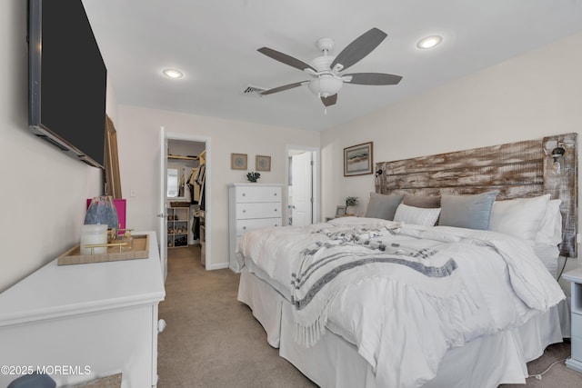 bedroom with visible vents, a closet, light carpet, recessed lighting, and a spacious closet