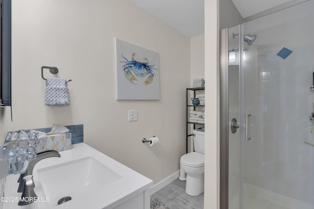 bathroom with vanity, baseboards, a shower stall, and toilet
