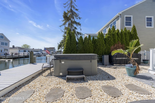 exterior space featuring a water view, a hot tub, and a boat dock