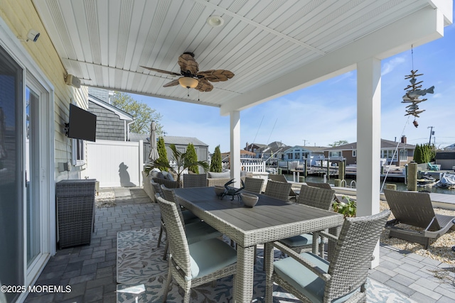 view of patio featuring ceiling fan, a residential view, cooling unit, a water view, and outdoor dining space