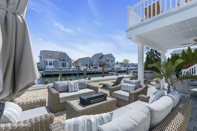 view of patio / terrace featuring a residential view, outdoor lounge area, a boat dock, a water view, and a balcony