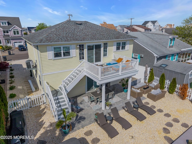 back of house with fence, a patio, a shingled roof, and a deck