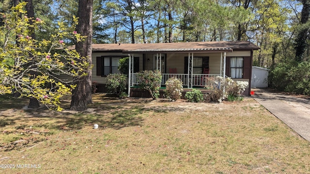 ranch-style home with a porch, concrete driveway, and a front lawn