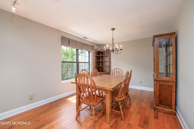 97 Gimbel Pl Unit 1903, Ocean Twp, NJ 07712 - dining space with a chandelier, light wood finished floors, a textured ceiling, and baseboards