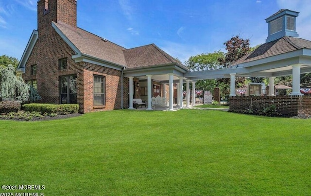 97 Gimbel Pl Unit 1903, Ocean Twp, NJ 07712 - rear view of property with a lawn, brick siding, a chimney, and roof with shingles