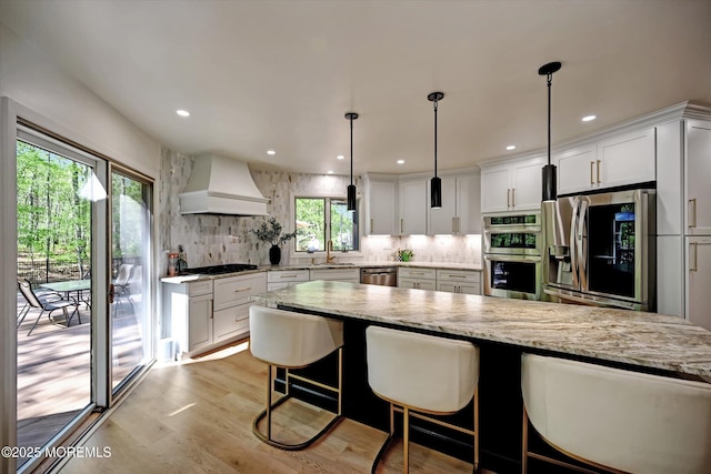 15 Evan Dr, Morganville, NJ 07751 - kitchen featuring custom exhaust hood, stainless steel appliances, a sink, backsplash, and light stone counters