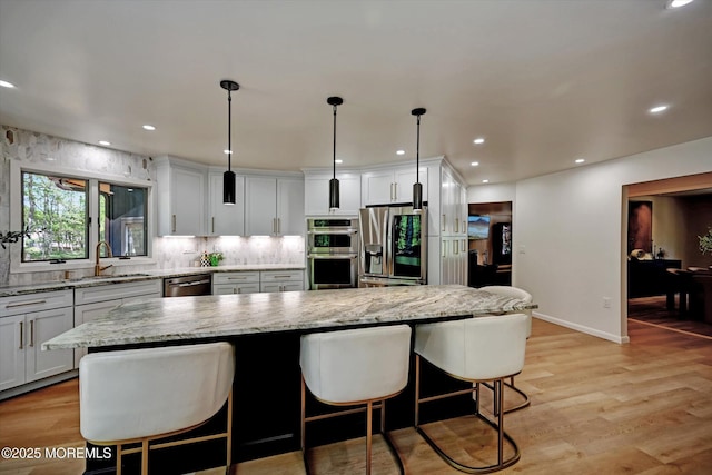 15 Evan Dr, Morganville, NJ 07751 - kitchen featuring stainless steel appliances, a sink, a kitchen island, light wood finished floors, and recessed lighting