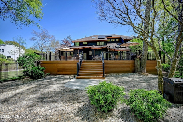 15 Evan Dr, Morganville, NJ 07751 - rear view of house featuring stairway, a deck, roof mounted solar panels, and fence
