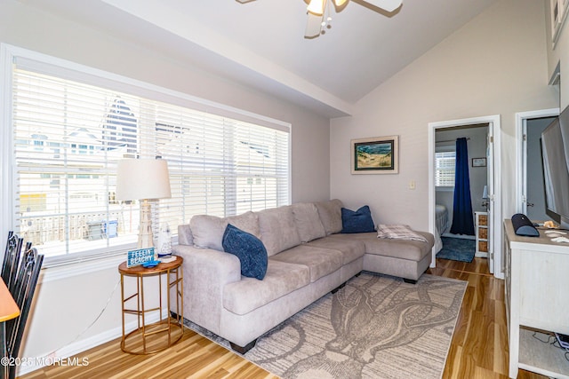 living room featuring a healthy amount of sunlight, baseboards, ceiling fan, and light wood-style floors