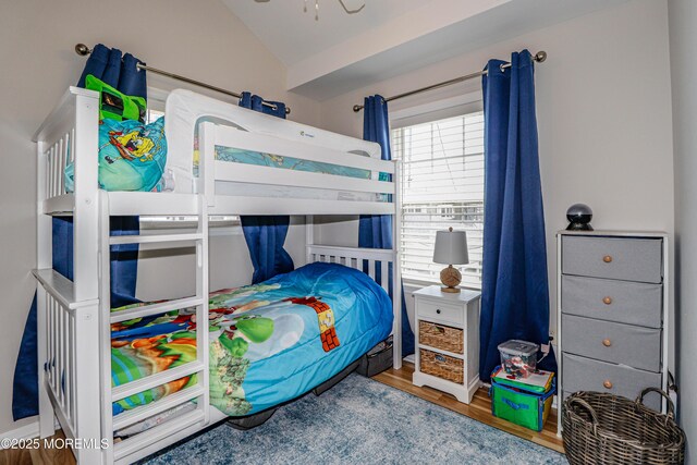 bedroom with wood finished floors and lofted ceiling