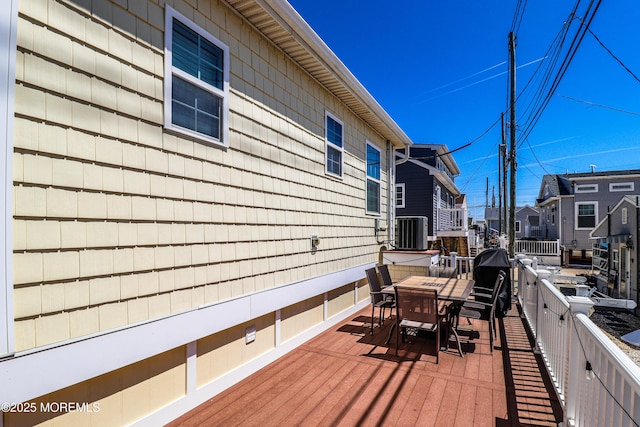 wooden deck featuring cooling unit and outdoor dining space