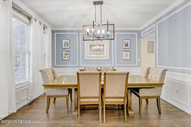 dining room with a chandelier, a healthy amount of sunlight, and a decorative wall