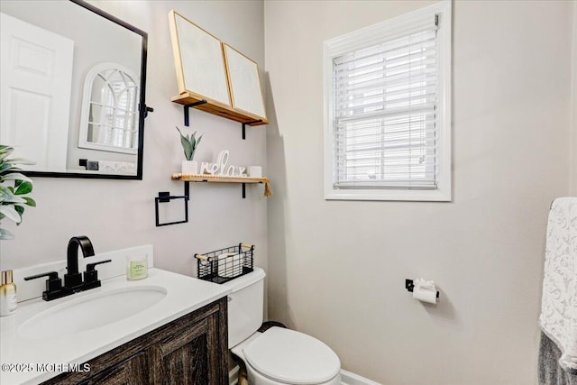 half bathroom featuring vanity and toilet
