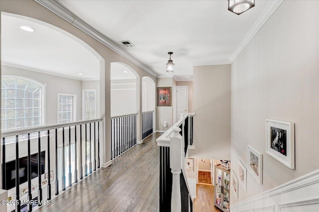 hall with visible vents, crown molding, arched walkways, wood finished floors, and recessed lighting