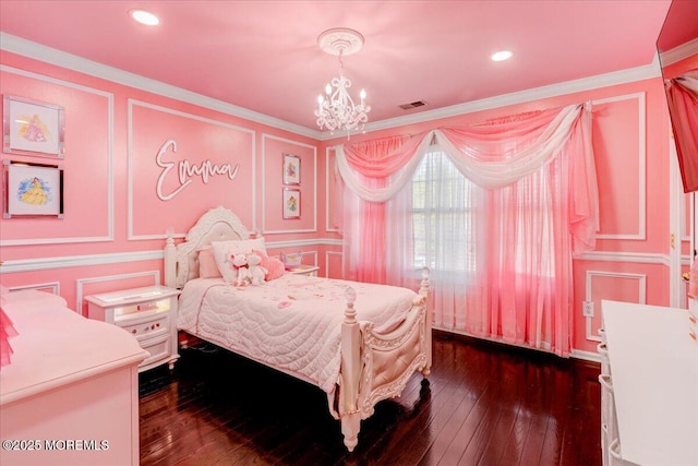 bedroom with visible vents, dark wood-style flooring, a decorative wall, and a chandelier
