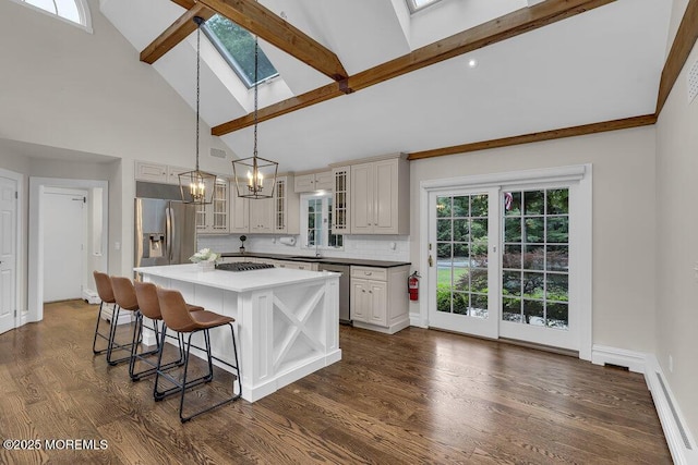 1570 Beaver Hollow Dr, Toms River, NJ 08755 - kitchen featuring a breakfast bar, high vaulted ceiling, a baseboard radiator, appliances with stainless steel finishes, and a skylight