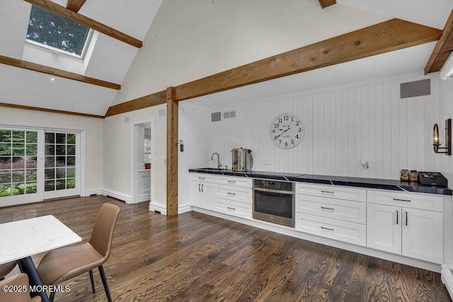 1570 Beaver Hollow Dr, Toms River, NJ 08755 - kitchen featuring beam ceiling, dark countertops, oven, dark wood-style floors, and white cabinets