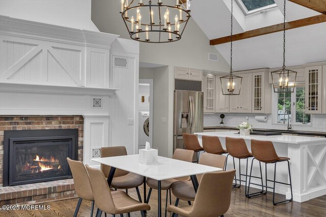 1570 Beaver Hollow Dr, Toms River, NJ 08755 - dining space with washer / clothes dryer, high vaulted ceiling, an inviting chandelier, and dark wood-style floors