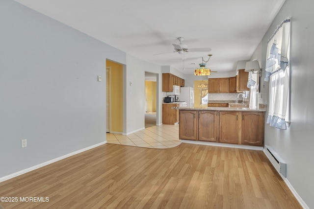 3 Tudor Ct, Brick, NJ 08723 - kitchen with brown cabinetry, a ceiling fan, baseboard heating, a peninsula, and white appliances