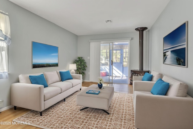 3 Tudor Ct, Brick, NJ 08723 - living area featuring baseboards, visible vents, wood finished floors, and a wood stove
