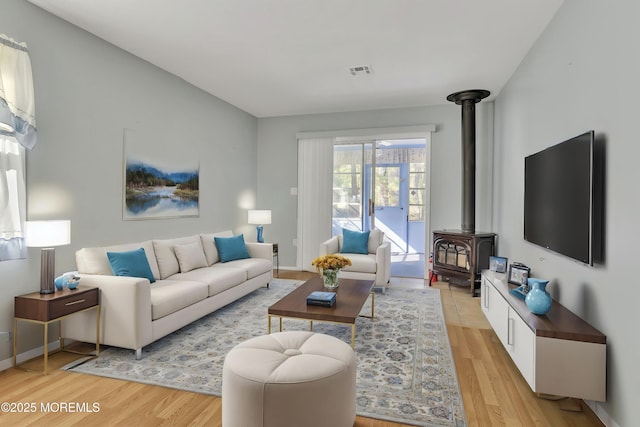 3 Tudor Ct, Brick, NJ 08723 - living area with visible vents, a wood stove, baseboards, and light wood-type flooring