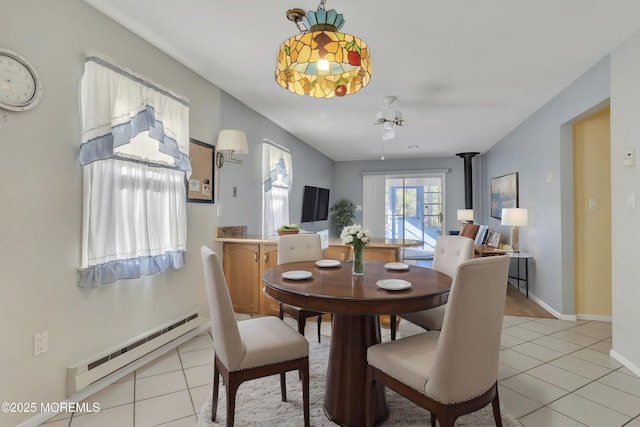 3 Tudor Ct, Brick, NJ 08723 - dining room with light tile patterned floors, a baseboard radiator, a wood stove, and ceiling fan