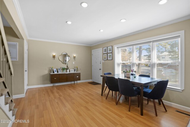 162 Tudor Ct, Lakewood, NJ 08701 - dining area with light wood finished floors, baseboards, visible vents, ornamental molding, and stairway