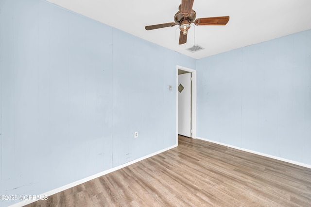 unfurnished room with wood finished floors, ceiling fan, and baseboards