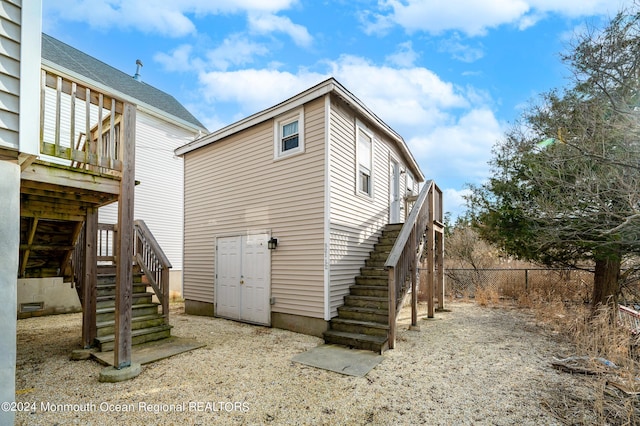 back of house with stairs, fence, and a deck