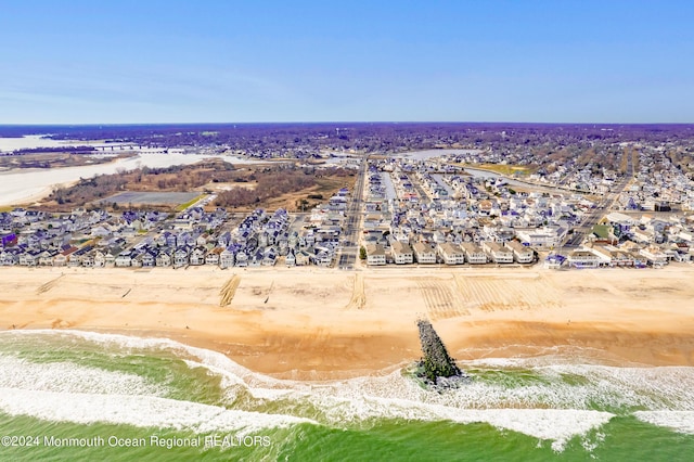 birds eye view of property featuring a water view, a view of the beach, and a residential view