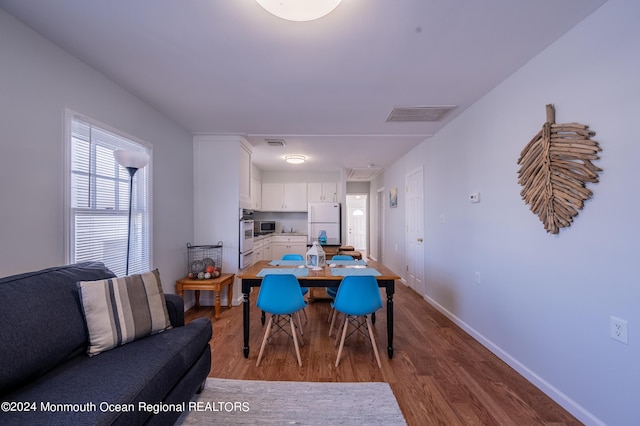 dining space featuring baseboards, visible vents, and wood finished floors